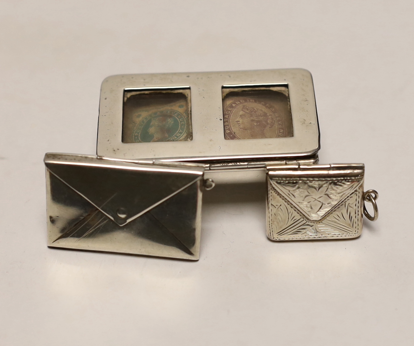 A late Victorian novelty silver double stamp case, modelled as a trough, Levi & Salaman, Birmingham, 1899 and two other silver or 925 'envelope' stamp cases.